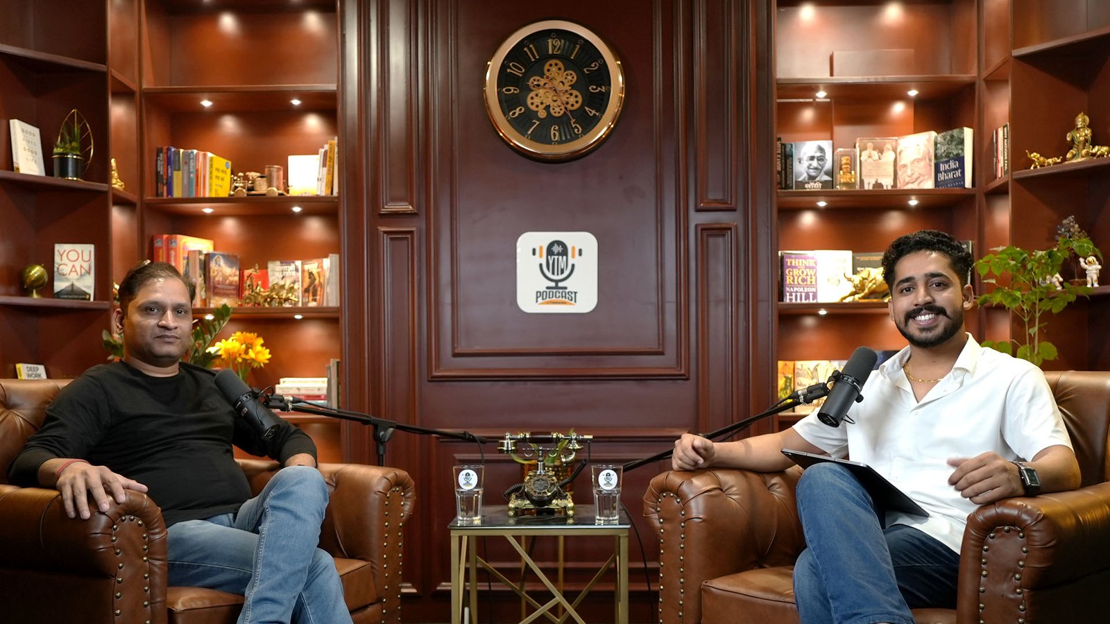 Two-person interview on the classic wooden library set, a typical setup for Jaipur content creators