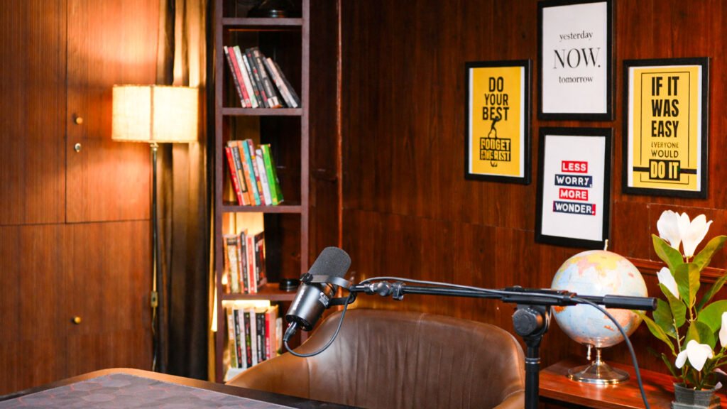 Podcast microphone arm and leather chairs in the professional setup with a bookshelf
