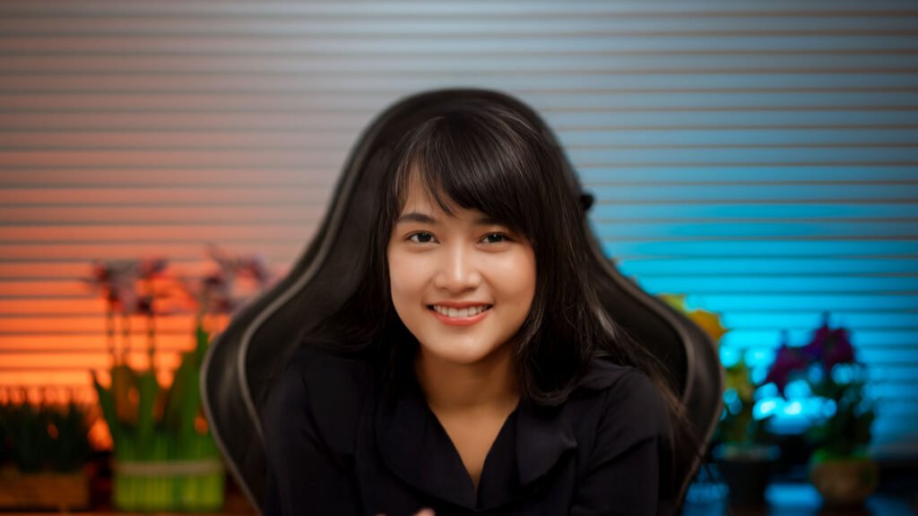 Woman content creator smiling in front of a grey panel wall, ready to shoot reels