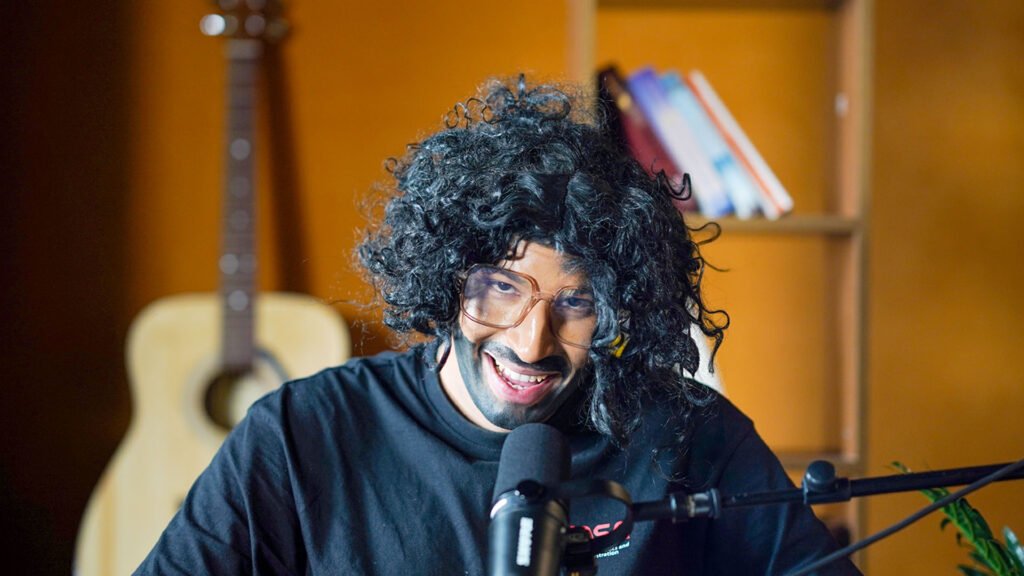 Content creator smiling at a Shure podcast microphone in the studio