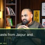 Podcast speaker talking into a Shure microphone on the dark wood office set at Oskillo Studio, Jaipur