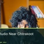 Solo creator on a mustard wall set with a guitar at Oskillo Studio, podcast studio near Chitrakoot, Jaipur